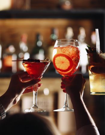 Friends toasting with cocktails in bar