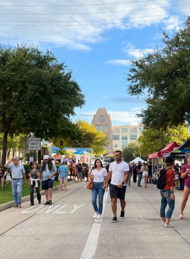 Shoppers walk the outdoor streets surround Frisco Square in TX