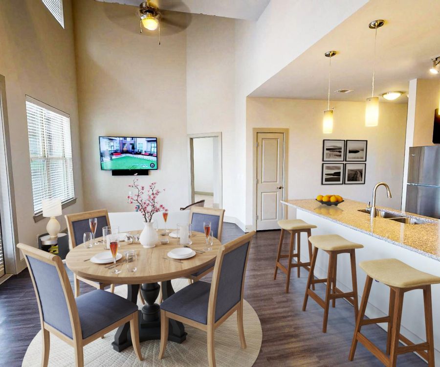 The Civic at Frisco Square apartment kitchen and dining area featuring large windows, granite countertop bar, and dining furniture