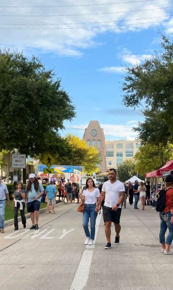 Shoppers walk the outdoor streets surround Frisco Square in TX