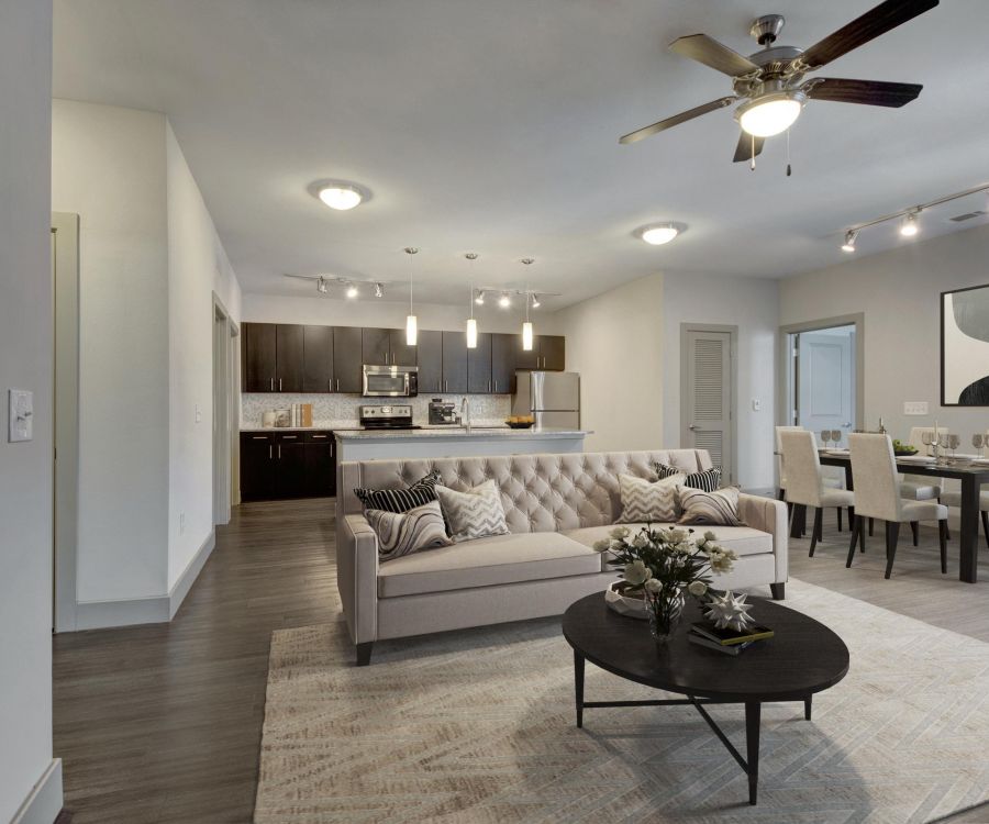 The Civic at Frisco Square apartment living room featuring contemporary furniture, wood plank flooring, and open kitchen